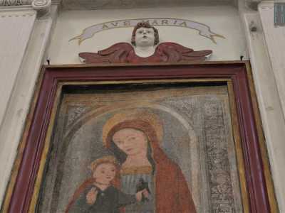 La Vergine � vestita con un vistoso mantello rossiccio: in braccio si nota Ges� che regge in mano un uccellino, sorvegliato dall'amorevole sguardo della madre